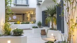 A modern courtyard with white walls, potted plants, and a seating area. - Cozy apartment in Marbella Old Town (Marbella)