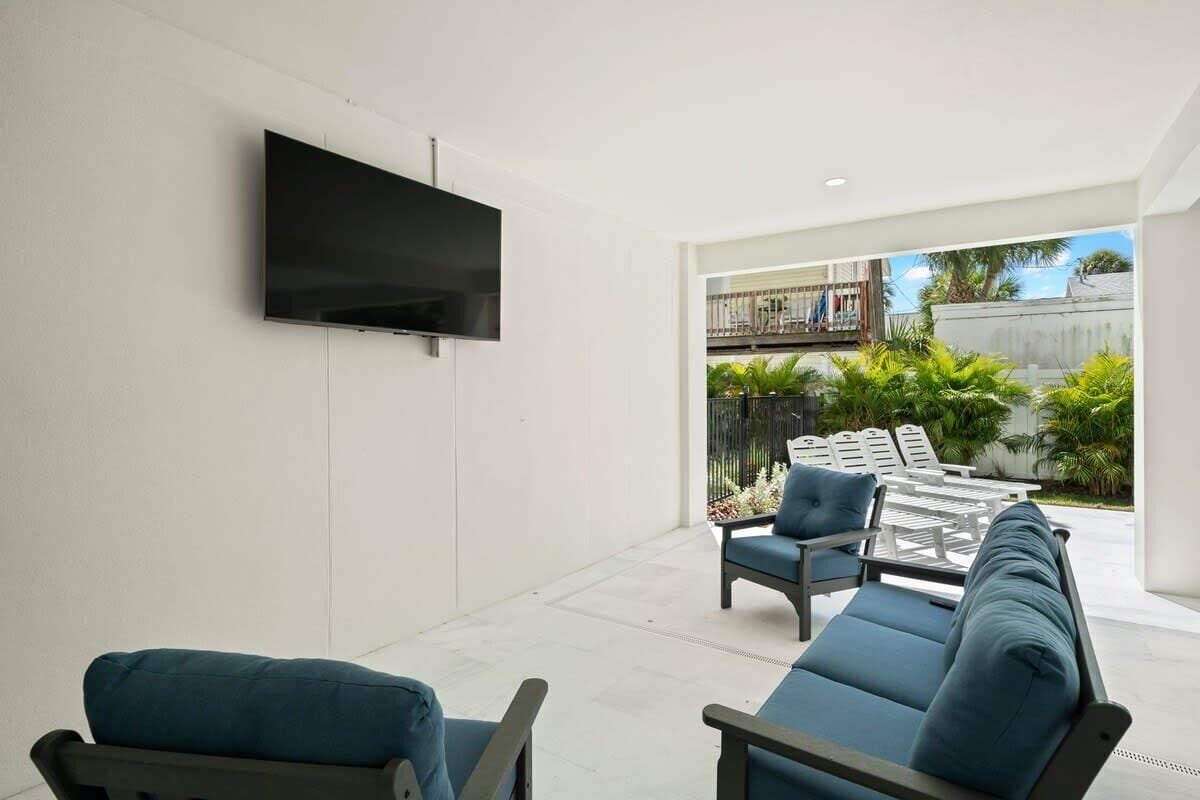 A modern living room with a flat-screen TV mounted on the wall, a sofa, and a coffee table.