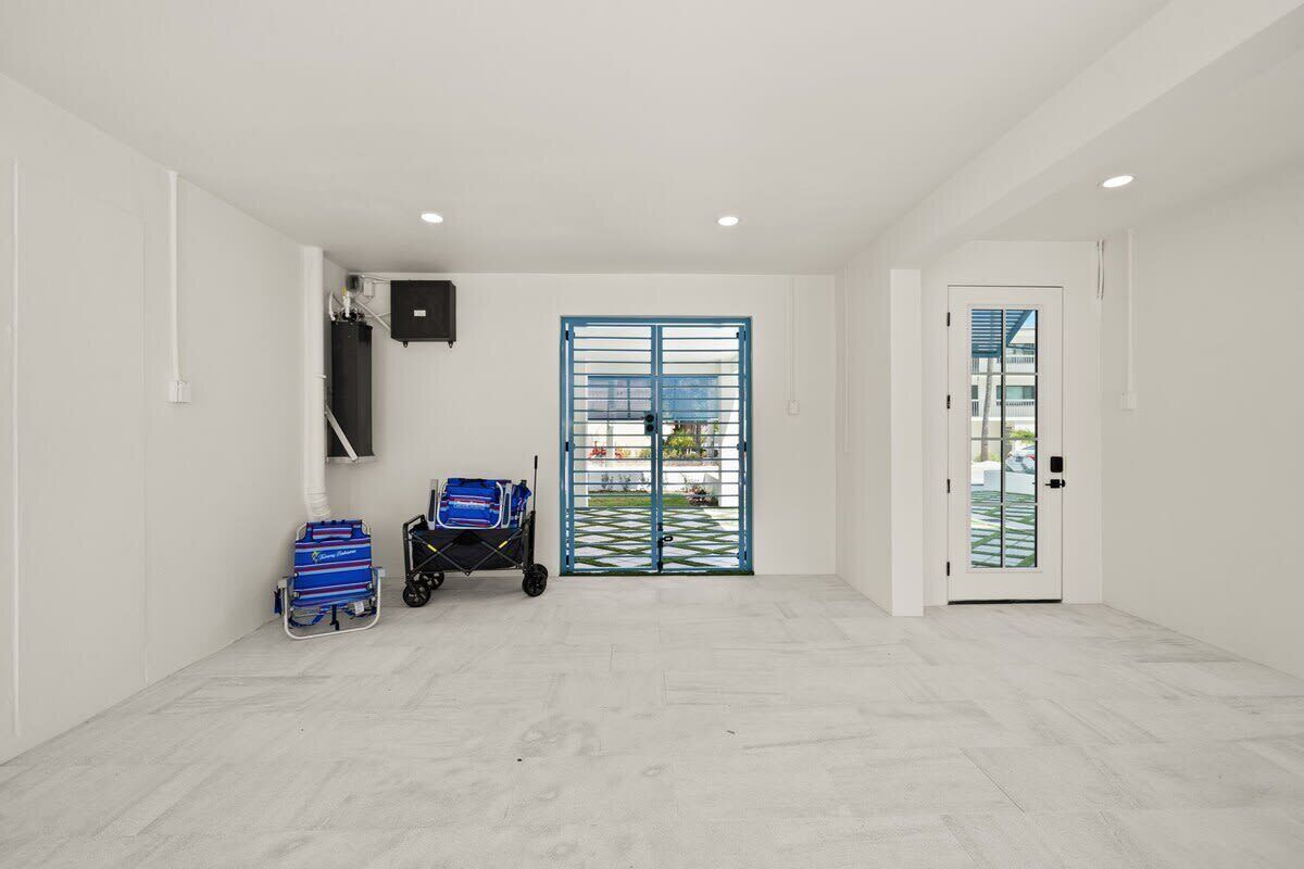 A clean, empty room with a white floor, a blue gate, and a white door.