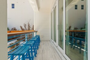 A balcony with blue wooden benches and a wooden railing.