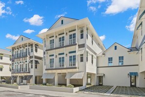 A modern multi-story residential building with a flat roof, large windows, and a covered outdoor area. - Pearl House at The Gemma (Clearwater)