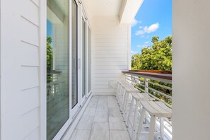 Ein Balkon mit weißen Geländern und einer hölzernen Bank.