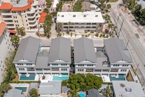 A multi-story hotel with a central courtyard featuring a swimming pool, surrounded by lush greenery.