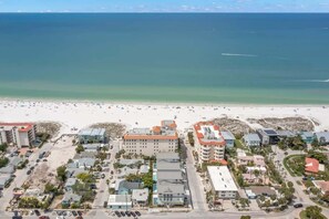 A coastal town with a beach, buildings, and parked cars. - Onyx House at The Gemma (Clearwater)