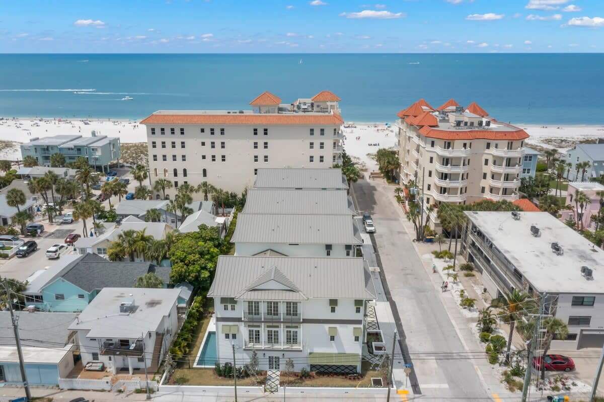 Un hôtel situé sur la côte, avec plusieurs étages, une piscine et une vue sur la plage.