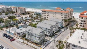 Ein Hotel an der Küste mit mehreren Etagen, einem Parkplatz und Blick auf den Strand.