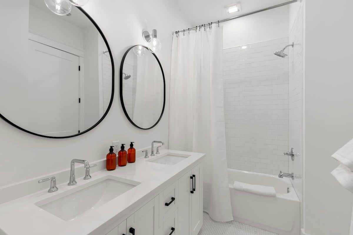 Une salle de bain moderne avec deux lavabos, une baignoire et une douche.