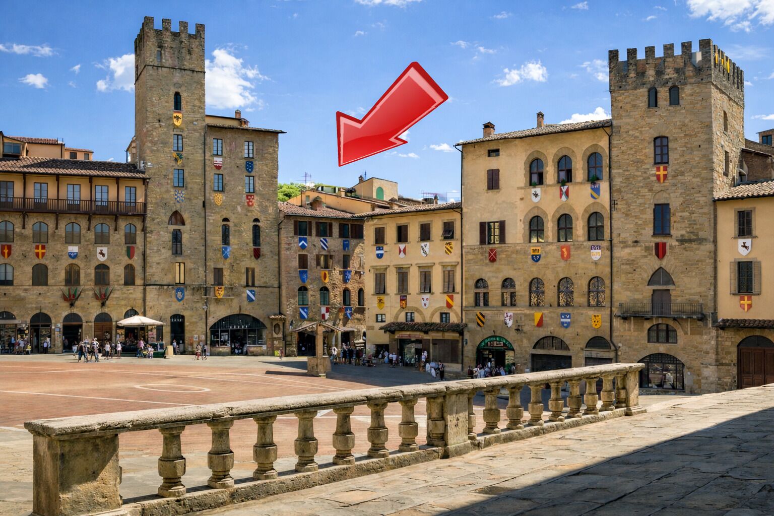 A historic building with multiple flags, a central courtyard, and stone railings.