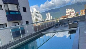 A rooftop pool with a clear view of the surrounding buildings and mountains. - Maravilhoso Apto a Beira Mar (Praia Grande)