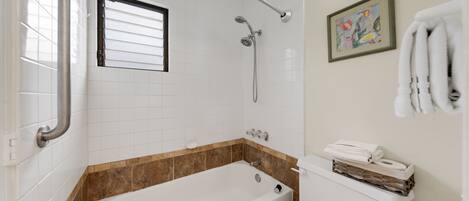 A bathroom with a bathtub, toilet, and a shower.