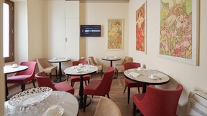 A dining area with round tables, red chairs, and white table settings. - Residenza Mondragone  (Florence)