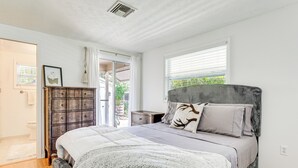 Un dormitorio con cama, cómoda y ventana.