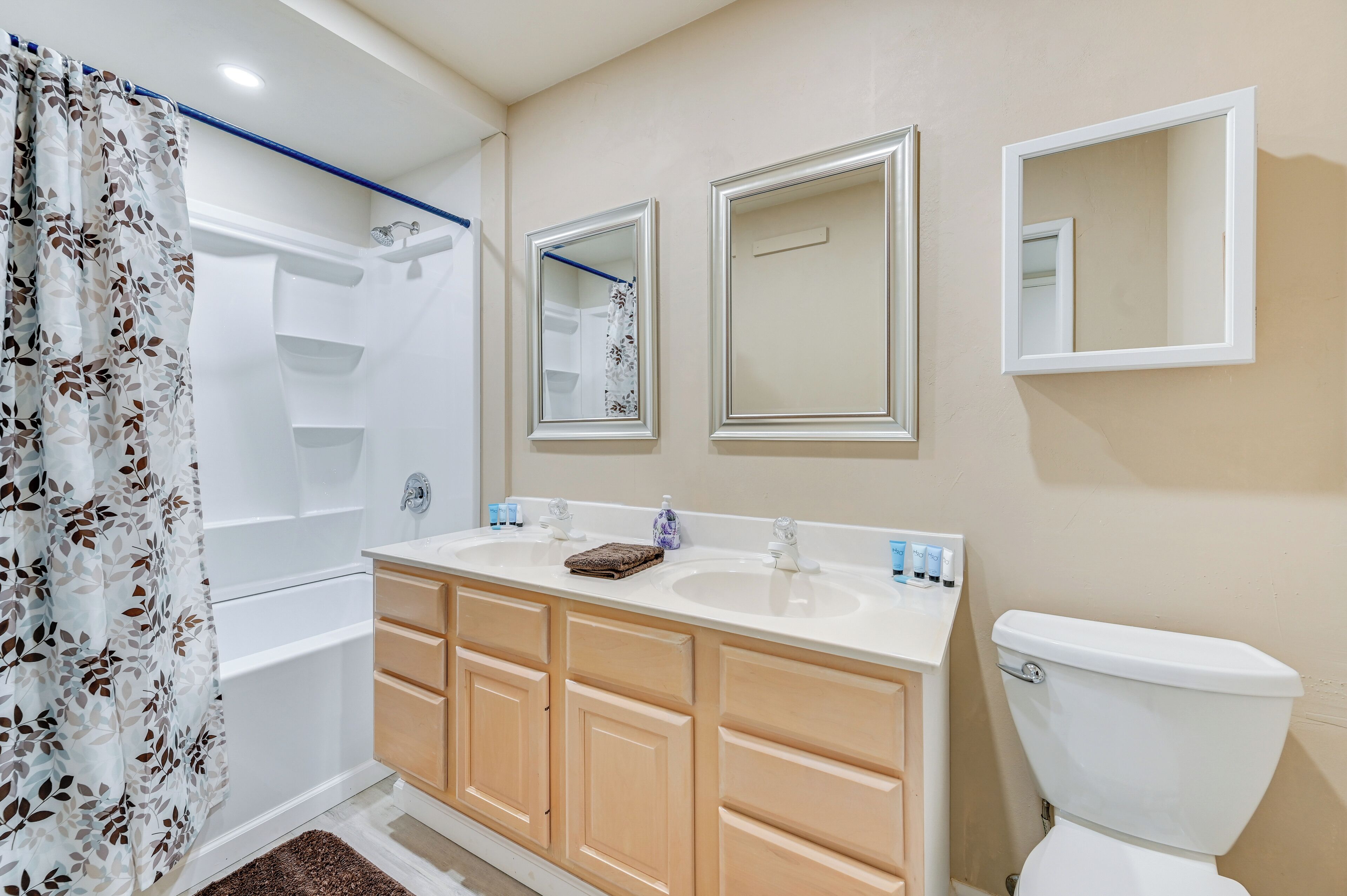 Un baño con tocador doble, ducha e inodoro.