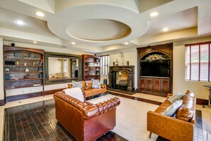 Cozy living room with a fireplace, bookshelves, and a flat-screen TV.
