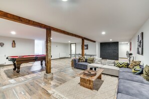 Un salon spacieux avec une table de billard, un canapé et une table basse.