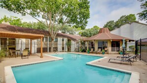 A swimming pool with lounge chairs and a covered seating area. - Chic Montgomery Condo w/ Balcony + Pool Access! (Montgomery)