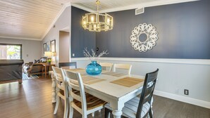 A dining area with a white table, chairs, and a blue vase centerpiece. - Near Golf & Beaches: Coral Springs Home w/ Yard! (Coral Springs)