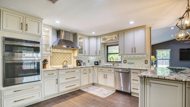 A modern kitchen with white cabinetry, stainless steel appliances, and a large island. - Near Golf & Beaches: Coral Springs Home w/ Yard! (Coral Springs)