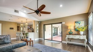 A spacious living room with a ceiling fan, a sofa, an ottoman, a coffee table, and a dining area with chairs and a table. - Near Golf & Beaches: Coral Springs Home w/ Yard! (Coral Springs)