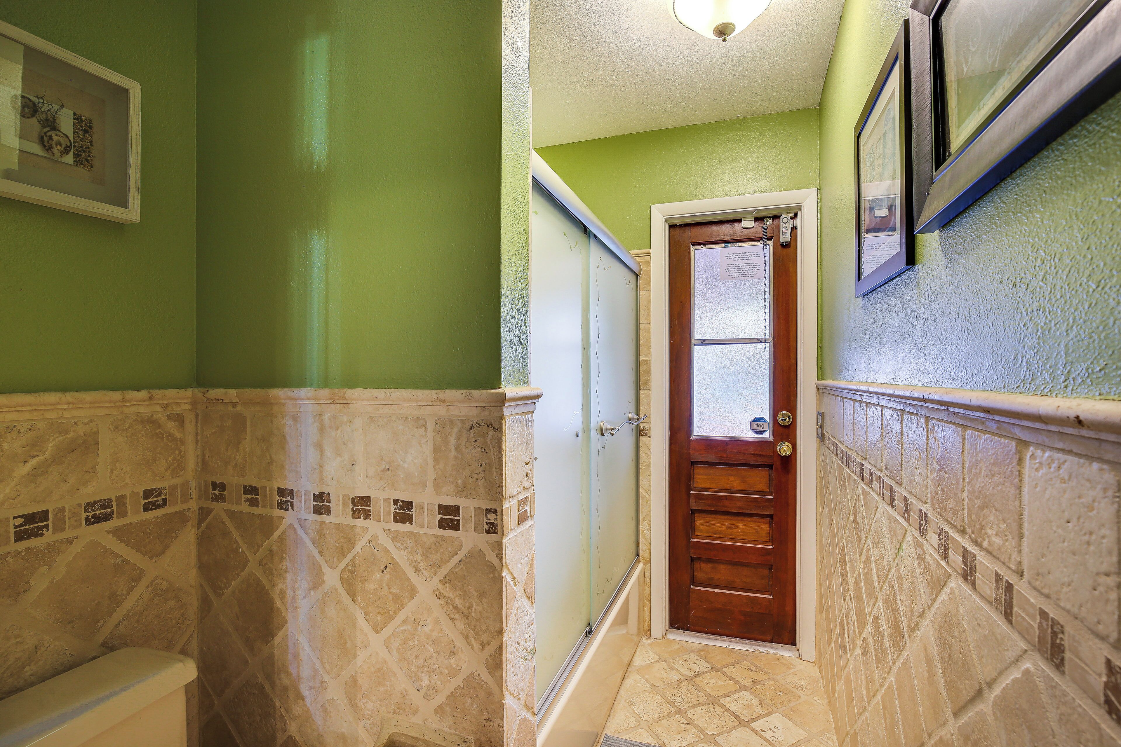 A bathroom with a toilet, a shower, and a sink.
