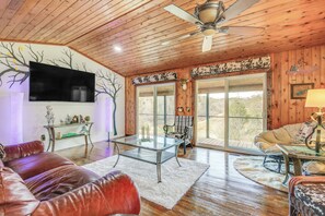 A cozy living room with a leather couch, a glass coffee table, and a fireplace. - Waterfront Dandridge Cabin, 24 Mi to Pigeon Forge! (Dandridge)