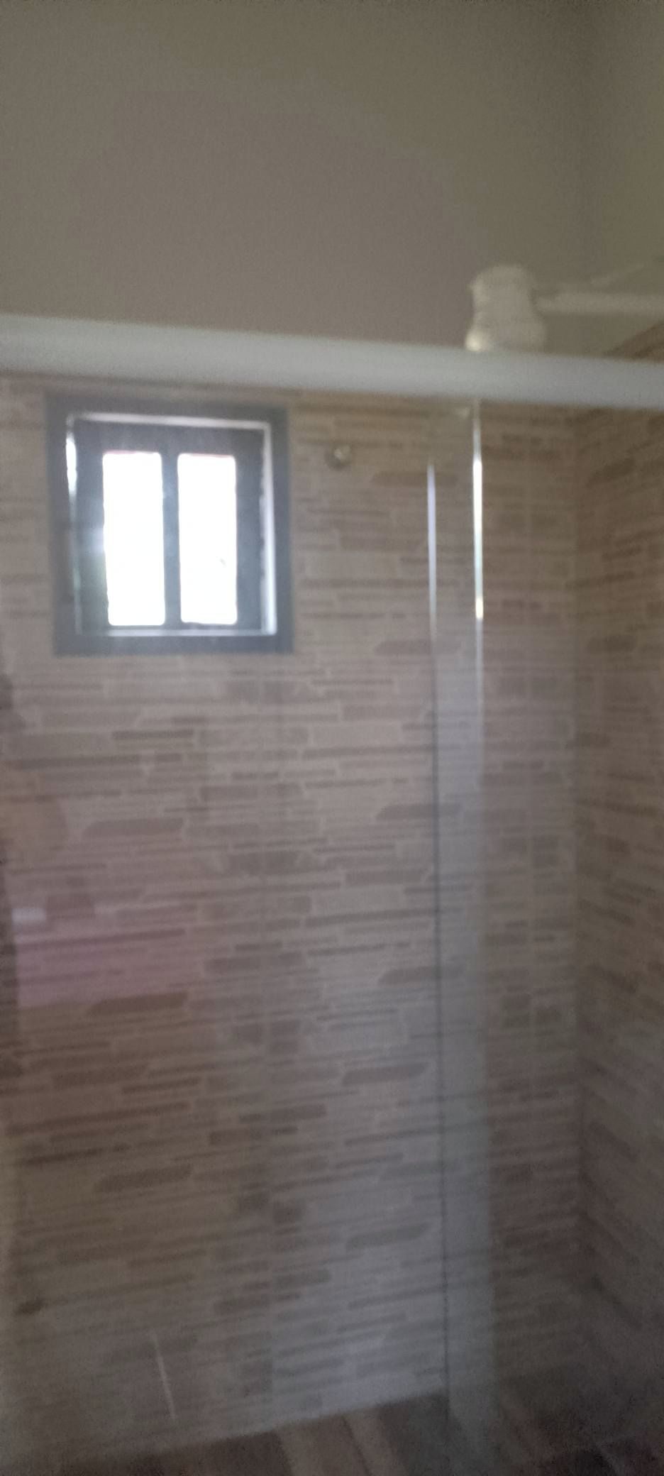 A room with a tiled wall and a small window.
