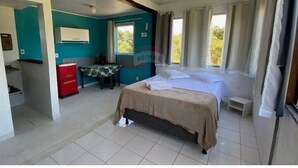 A bedroom with a bed, a desk, and a chair. There is a window with curtains and a ceiling fan. - FLATS ARPOADOR DE BÚZIOS (Búzios)