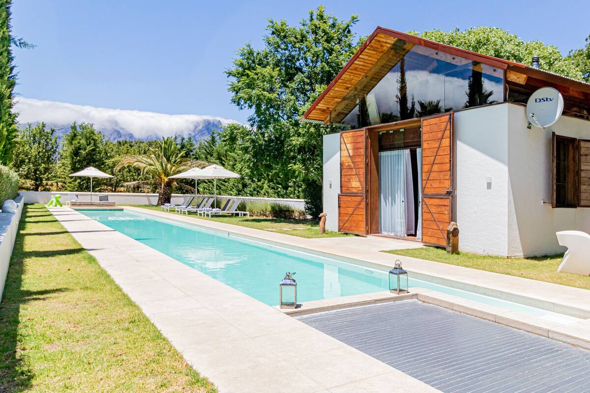 A modern building with a pool, outdoor seating, and a satellite dish.