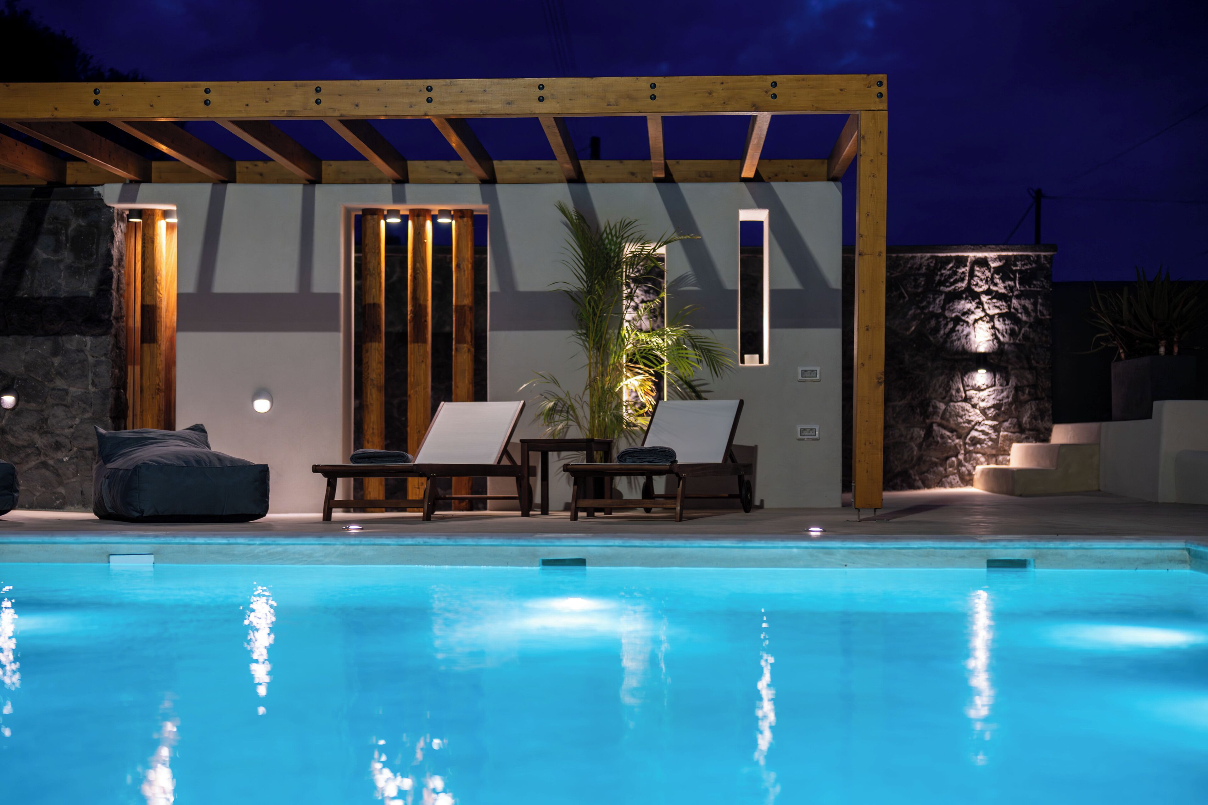 A swimming pool with lounge chairs and a pergola structure.