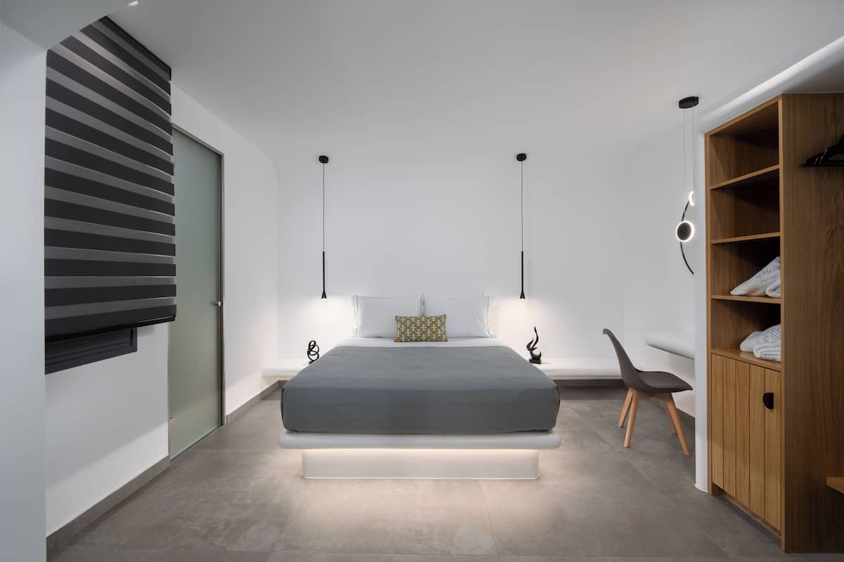 Un dormitorio moderno con una cama grande, mesitas de noche, un armario y una puerta corredera.