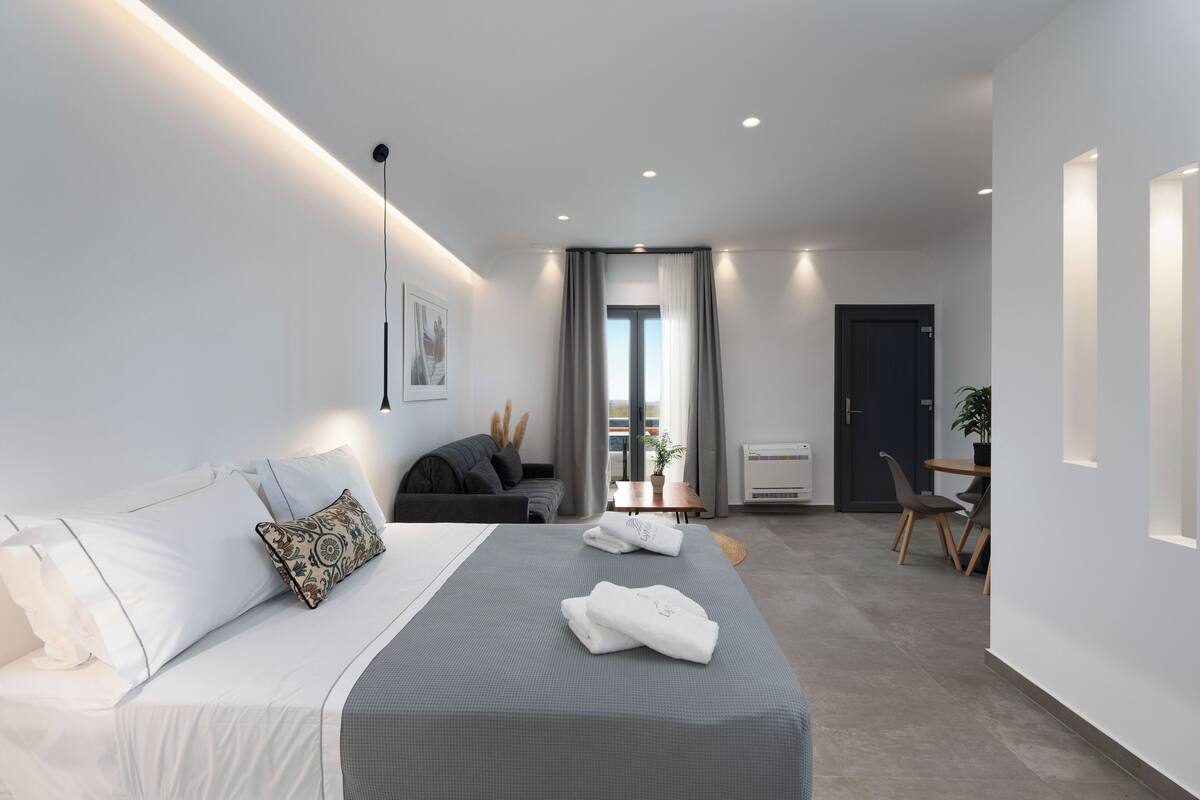 Una habitación de hotel moderna con una cama grande, un escritorio y un rincón de comedor.