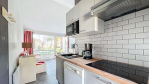 A compact kitchen with a microwave, coffee maker, and a dishwasher. - Maison Dans Résidence Avec Piscine (Dolus-d'Oléron)