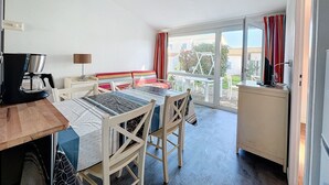 A room with a bed, a desk, a coffee maker, and a view of the outside. - Maison Dans Résidence Avec Piscine (Dolus-d'Oléron)