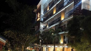 Un hotel de varios pisos con asientos exteriores y una fuente.
