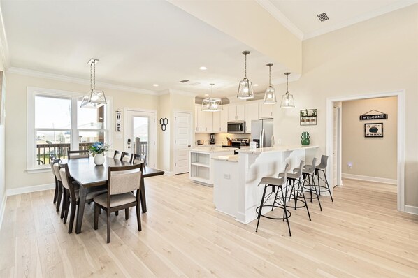 A spacious kitchen with a central island, pendant lighting, and a view to the outdoors.
