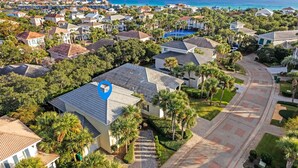 Un quartier résidentiel avec des maisons, des palmiers et une vue dégagée sur l’océan.