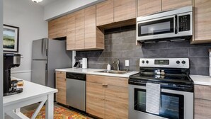 A modern kitchen with wooden cabinets, stainless steel appliances, and a dishwasher. - 25% Off Sept,  Inks Suite, 1 Block To Downtown! (Marble Falls)