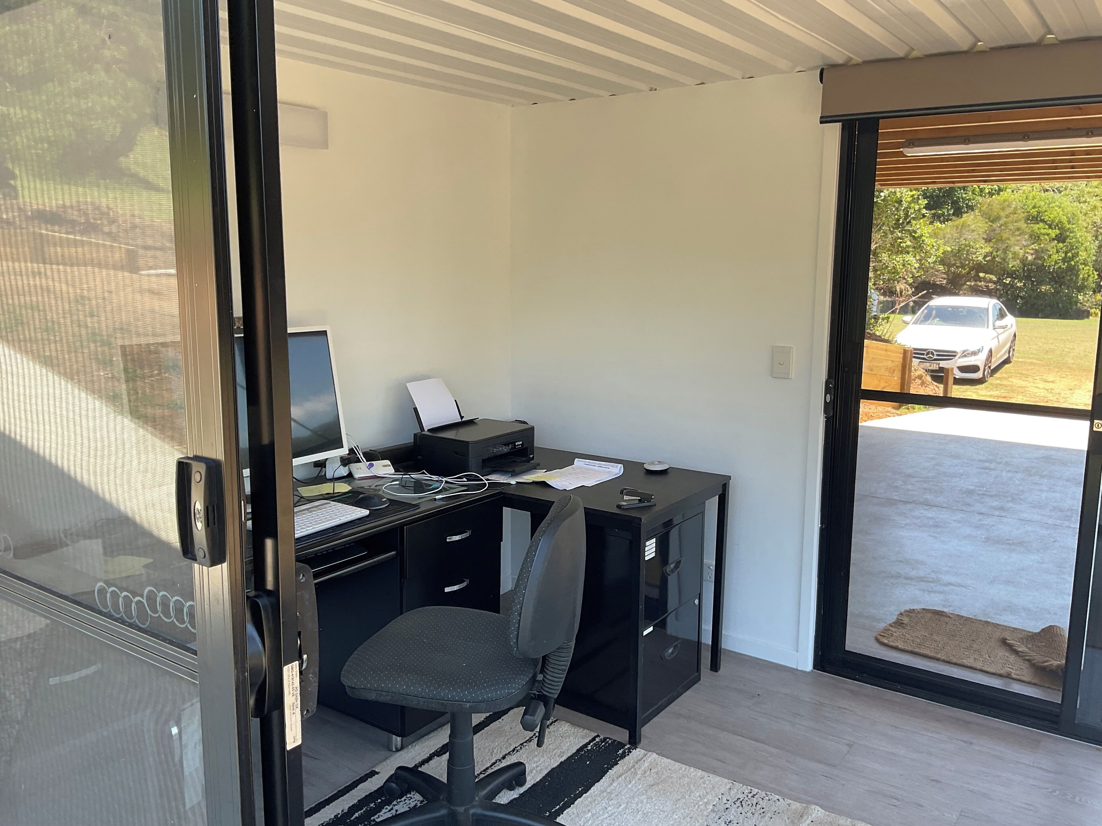 Un espacio de oficina moderno con escritorio, silla y computadora.