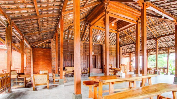 A spacious wooden pavilion with high ceilings and a brick wall interior. - Capital O 93873 Sokkyo Homestay (Ngaglik)