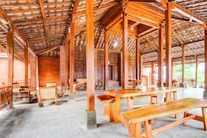 A spacious wooden pavilion with high ceilings and a brick wall interior. - Capital O 93873 Sokkyo Homestay (Ngaglik)