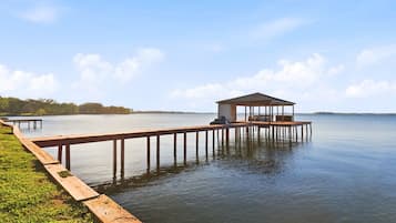 Un muelle de madera que se adentra en aguas tranquilas, con una estructura cubierta al final.