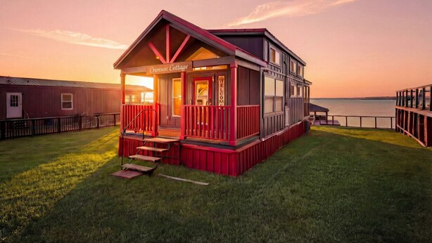 A two-story cottage with a red exterior, a porch, and a sign that reads 'Chesley Cottage.' - Lake Front Cottage Paradise! (Pittsburg)