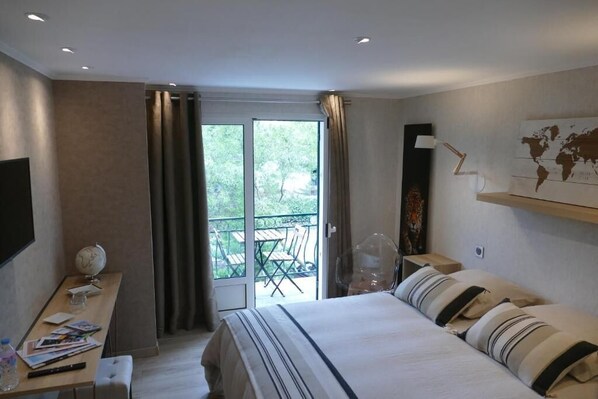 Een hotelkamer met een bed, een bureau met een wereldbol, een stoel en uitzicht op de omgeving.
