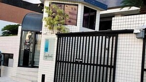 Une entrée fermée par un portail en métal, une enseigne indiquant « Luz & Luna », et un bâtiment dont la façade est recouverte de carreaux.