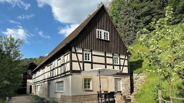 Ein traditionelles Fachwerkhäuschen mit einem Steinweg, der zur Eingangstür führt.