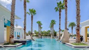 A swimming pool surrounded by palm trees, with a clear blue sky above. - ☀️Short, Easy Walk to Carillon Beach-Pool + Hot Tub-Tennis Court-Lily Pad☀️ (Panama City Beach)