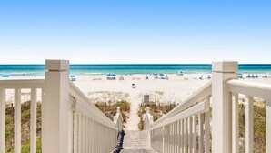 A beach view from a staircase leading to a sandy beach with umbrellas. - ☀️Short, Easy Walk to Carillon Beach-Pool + Hot Tub-Tennis Court-Lily Pad☀️ (Panama City Beach)