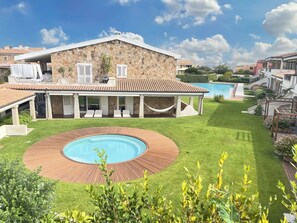 A stone villa with a swimming pool, a covered patio, and a well-maintained lawn. - LIKE at HOME ​PALAU n° 11 Poolside Paradise Patio (Palau)