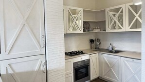 A kitchen with white cabinetry, a gas stove, and a built-in oven. - LIKE at HOME ​PALAU n° 11 Poolside Paradise Patio (Palau)