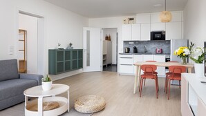 A modern apartment with a living room, dining area, and kitchen.